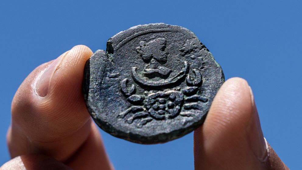 A rare, nearly 1,850-year-old bronze coin discovered off the Israeli coastal city of Haifa is on display at Israel's Antiquities Authority office in Jerusalem, Tuesday, July 26, 2022. The coin bears the image of the zodiac sign Cancer behind a depict