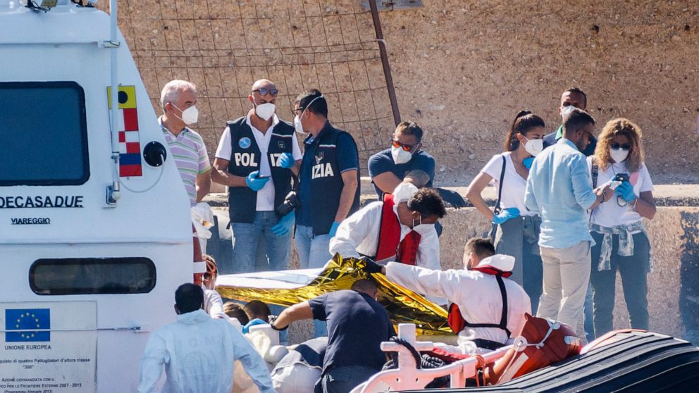 Bodies are disembarked on the tiny Sicilian island of Lampedusa, Italy, Friday, Oct. 21, 2022. Italy's coast guard says it has found two dead minors on a migrant boat carrying nearly 40 people in the Mediterranean Sea, and a search is under way for a