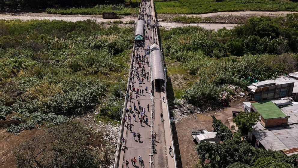 People use the Simon Bolivar International Bridge to cross between San Antonio, Venezuela, top, and Cucuta, Colombia, Friday, Aug. 5, 2022. The border has been partially closed for years by the Venezuelan government, and will gradually reopen after t