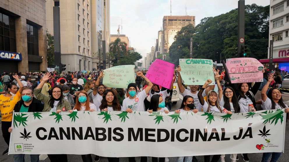 Demonstrators hold a banner that reads in Portuguese: "Medical Cannabis Now," during a legalization of marijuana march in Sao Paulo, Brazil, Saturday, June 11, 2022. (AP Photo/Andre Penner)