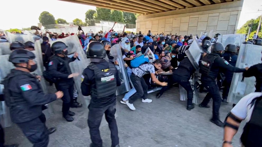 A caravan of migrants, most from Central America, break through a Mexican police barricade in Tapachula, Mexico, Saturday, Oct. 23, 2021. Immigration activists say they will lead migrants out of the southern Mexico city of Tapachula Saturday at the s