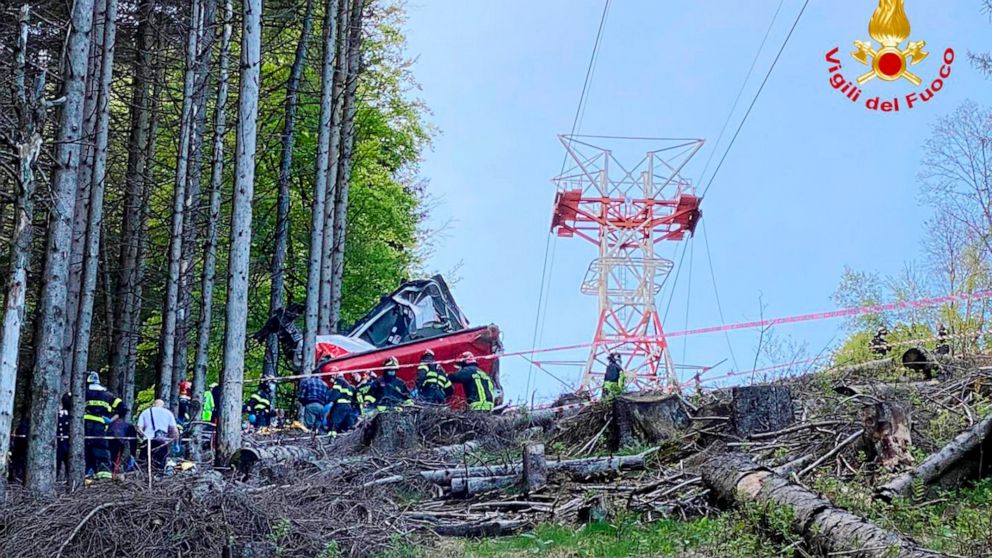 Rescuers work by the wreckage of a cable car after it collapsed near the summit of the Stresa-Mottarone line in the Piedmont region, northern Italy, Sunday, May 23, 2022. A cable car taking visitors to a mountaintop view of some of northern Italy's m