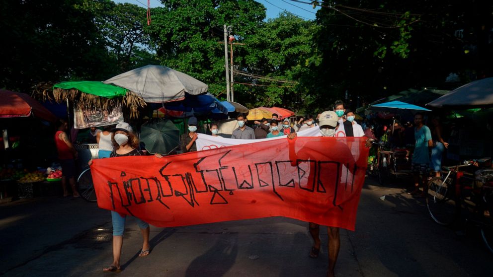 FILE - People march to protest against the February military takeover, in Yangon, Myanmar, on April 11, 2021. The banner reads, "Absolutely no dictatorship." Japanese video journalist Toru Kubota has been detained by security forces in Myanmar while 