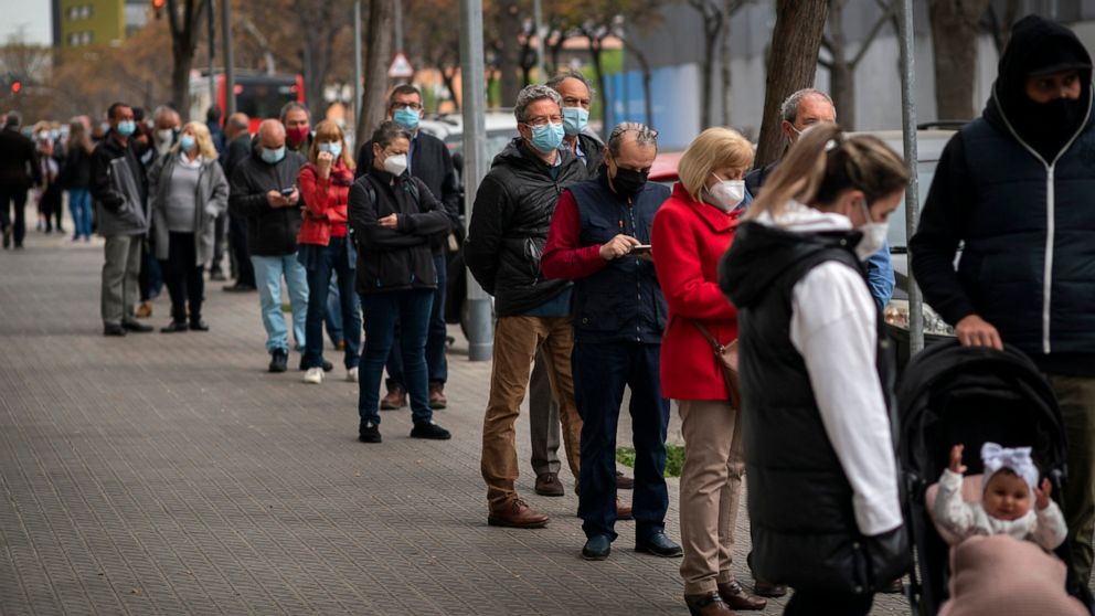 People line up outside a public ambulatory as they wait to receive a dose of the AstraZeneca vaccine in Barcelona, Spain, Tuesday, April 6, 2021.Spanish Prime Minister Pedro Sánchez says a steep rise in vaccine deliveries over coming months will allo