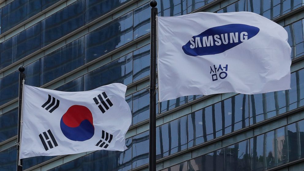 A Samsung Group flag and South Korean national flag flutter at its office in Seoul, South Korea, Wednesday, May 6, 2020. Samsung heir Lee Jae-yong on Wednesday expressed remorse but offered no clear admission of wrongdoing over his alleged involvemen