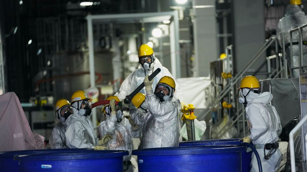 FILE - Men in hazmat suits work inside a facility with equipment to remove radioactive materials from contaminated water at the Fukushima Daiichi nuclear power plant, run by Tokyo Electric Power Company Holdings (TEPCO), in Okuma town, northeastern J