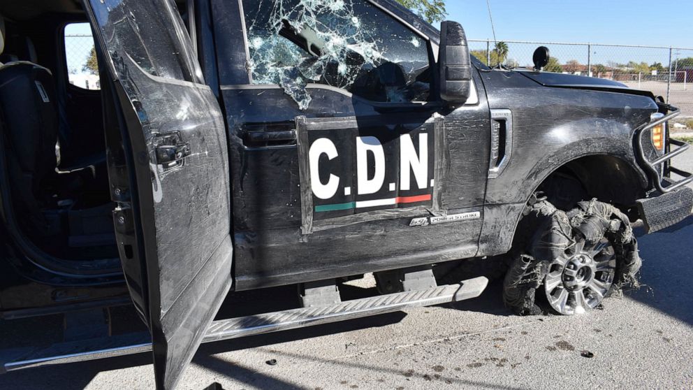 A damaged pick up truck marked with the initials C.D.N., that in Spanish stand for Cartel of the Northeast, stands on the street after a gun battle between Mexican security forces and suspected cartel gunmen, in Villa Union, Mexico, Sunday, Dic. 1, 2