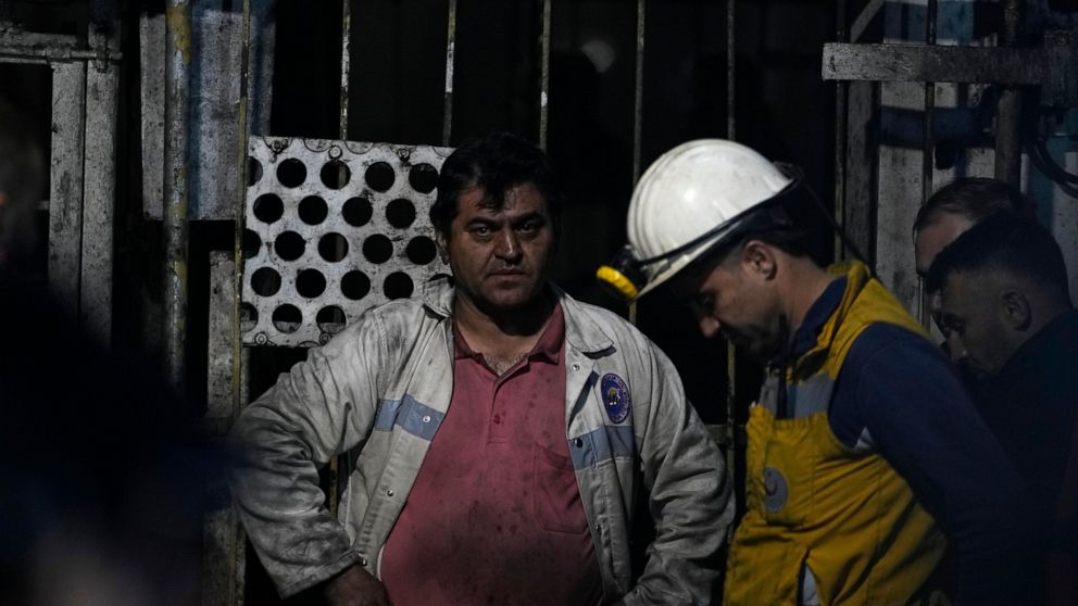 Miners and rescue members wait in front of the mine in Amasra, in the Black Sea coastal province of Bartin, Turkey, Saturday, Oct. 15, 2022. Officials say a deadly explosion occurred inside a coal mine in northern Turkey, trapping dozens of miners. (