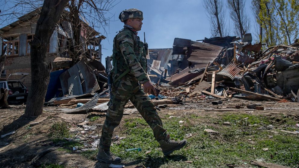 An Indian paramilitary soldier walks past a house destroyed during a gunbattle in Pulwama, south of Srinagar, Indian controlled Kashmir, Friday, April 2, 2021. Anti-India protests and clashes have erupted between government forces and locals who thro