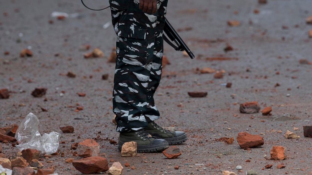 FILE- In this May 24, 2019 file photo, an Indian paramilitary soldier stands guard on a road dotted with bricks thrown at them by Kashmiri protestors in Srinagar, Indian controlled Kashmir. Police say a top commander of a Pakistan-based militant grou