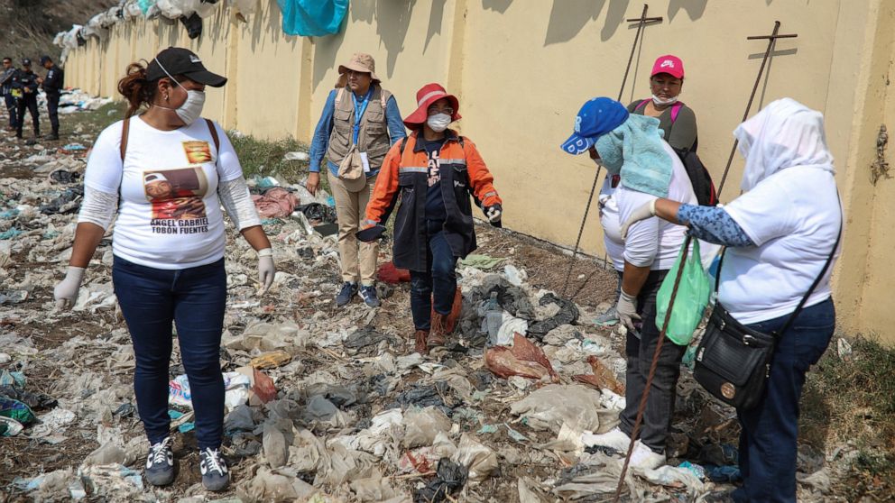 FILE - Members of the Solecito Collective who are seeking their missing loved ones look for signs of clandestine graves inside a municipal dump in the port city of Veracruz, Mexico, March 11, 2019. Mexican activists filed a criminal complaint Wednesd