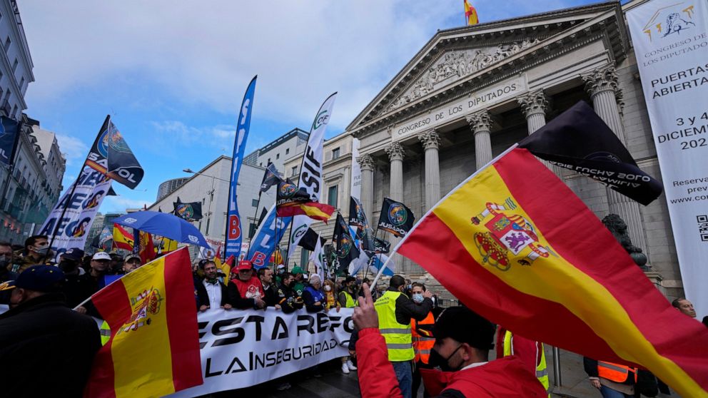 Police march past the Spanish parliament during a protest march in Madrid, Spain, Saturday, Nov. 27, 2021. Tens of thousands of Spanish police officers and their supporters rallied in Madrid on Saturday to protest against government plans to reform a