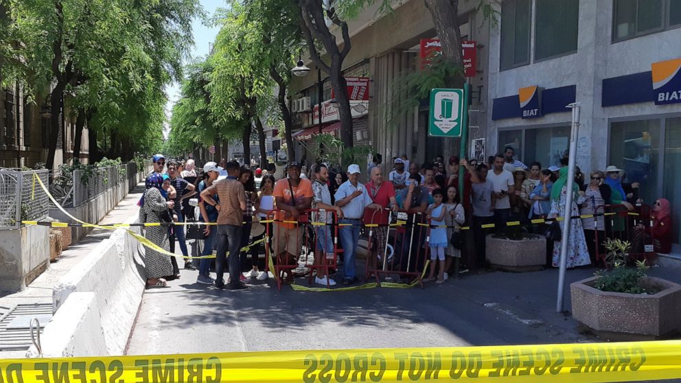 People are prevented to enter a security area after an explosion in Tunis, Thursday June 27, 2019. The Tunisian Interior ministry said one police officer has died in the suicide bombing targeting a police patrol in a busy commercial street in central