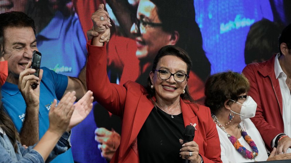 Free Party presidential candidate Xiomara Castro has her hand raised by her running mate Salvador Nasralla after general elections, in Tegucigalpa, Honduras, Sunday, Nov. 28, 2021. Castro claimed victory, setting up a showdown with the National Party