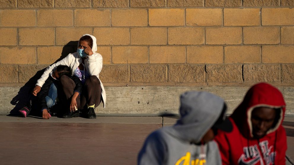 FILE - Asylum seekers wait for news of policy changes at the border on Feb. 19, 2021, in Tijuana, Mexico. The Biden administration is set to reinstate a Trump-era policy to make asylum-seekers wait in Mexico for hearings in U.S. immigration court thi