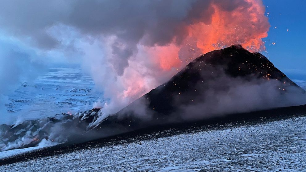 FILE - Flames and smoke billowing during the Klyuchevskaya volcano's eruption on the Kamchatka Peninsula in Russia, on March 8, 2021. Towering clouds of ash and glowing lava are spewing from two volcanoes on the Kamchatka Peninsula and scientists say