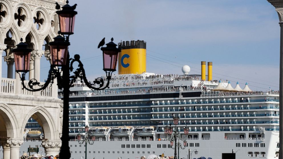 FILE-- A cruise ship passes by St. Mark's Square filled with tourists, in Venice, Italy, Sunday, June 2, 2019. Declaring Venice's waterways a “national monument,” Italy is banning mammoth cruise liners from sailing into the lagoon city, which risked 