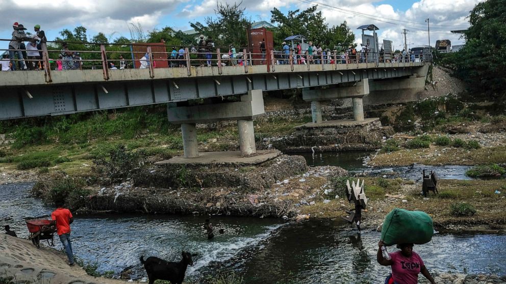FILE - People bathe in the Massacre River on the border between Dominican Republic and Haiti, in Ouanaminthe, Dominican Republic, Nov. 19, 2021. Dominican authorities have expelled at least 1,800 unaccompanied Haitian migrant children in 2022 back to