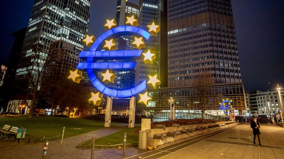 FILE - In this Thursday, March 11, 2021 file photo, a man walks past the Euro sculpture in Frankfurt, Germany. The European Union’s statistics agency says sharply higher oil and gas prices helped push annual inflation in the 19 countries that use the