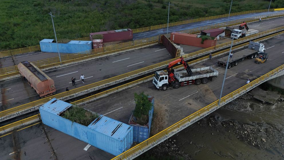 Venezuelan personnel remove containers that were blocking the Tienditas International Bridge, the international border between Venezuela and Colombia, in Cucuta, Colombia, Thursday, Dec. 15, 2022. Venezuelan President Nicolas Maduro announced his dec