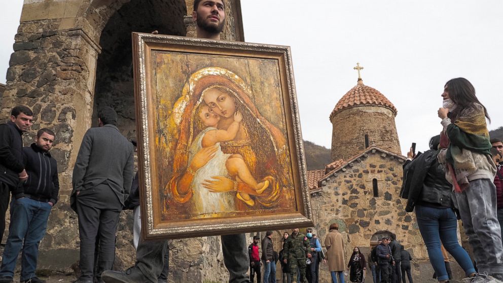 A man holds an icon from the Dadivank, an Armenian Apostolic Church monastery dating to the 9th century, as ethnic Armenians leave the separatist region of Nagorno-Karabakh to Armenia, Saturday, Nov. 14, 2020. The territory is to be turned over to Az