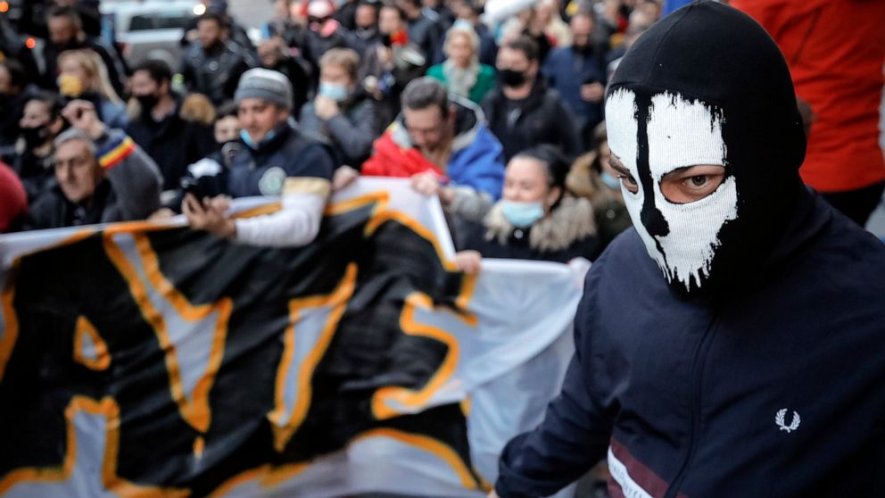 People protesting against the COVID-19 pandemic restrictions march downtown in Bucharest, Romania, Monday, March 29, 2021. Thousands of anti-restriction protesters took to the streets in several cities across Romania on Monday evening, a day after ne