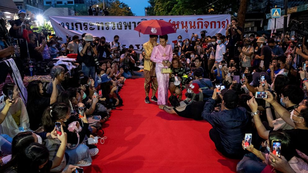 FILE - Pro-democracy protesters perform on a mock "red carpet" fashion show billed as a sort of counterpoint to a fashion show being held by one of the monarchy's princesses nearby in Bangkok, Thailand on Oct. 29, 2020. A court in Thailand on Monday,