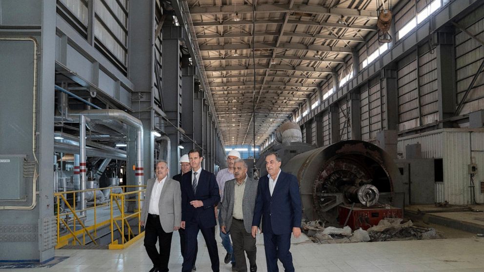In this photo released on the official Facebook page of Syrian Presidency, Syrian President Bashar Assad, second left, visits a power station in the eastern part of Aleppo province, Syria, Friday, July 8, 2022. Assad made a rare visit to the northern