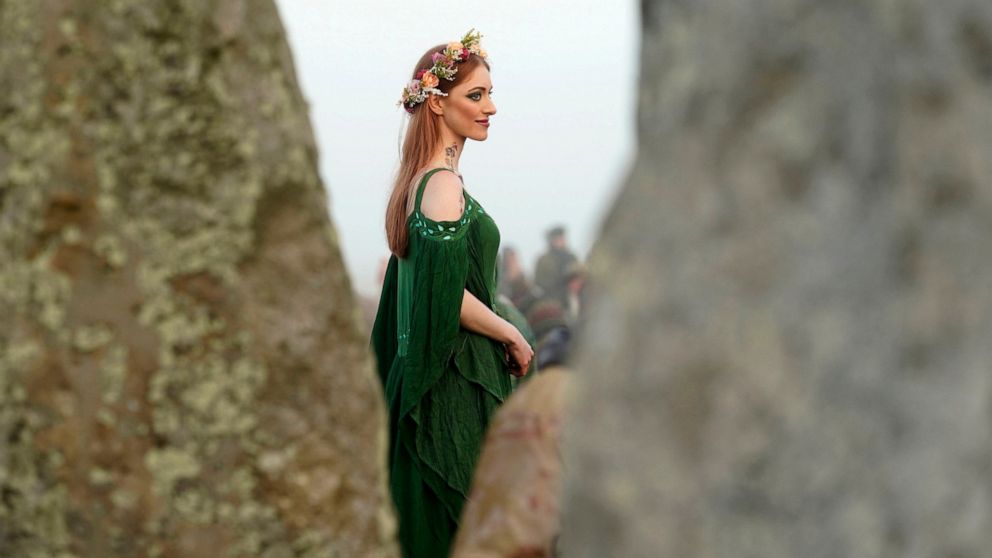 Pagan kıyafetleri giymiş bir kadın, 21 Haziran 2022, İngiltere, Wiltshire'daki Stonehenge'deki Yaz Gündönümü şenlikleri sırasında güneşin doğuşunu izliyor. COVID-19 salgını nedeniyle iki yıl kapalı kalan Stonehenge, Pazartesi günü Summe için yeniden açıldı.