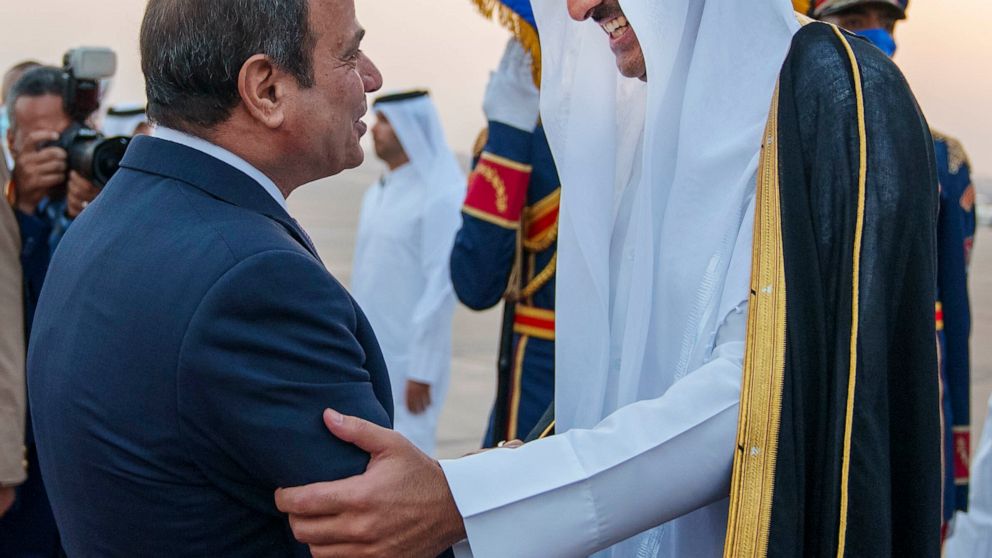 In this photo made available by Qatar News Agency, QNA, Qatari Emir Tamim bin Hamad Al Thani, right, is welcomed by Egyptian President Abdel-Fattah el-Sissi upon his arrival at Cairo airport, in Cairo, Egypt, Friday, June 24, 2022. Qatar's emir arriv
