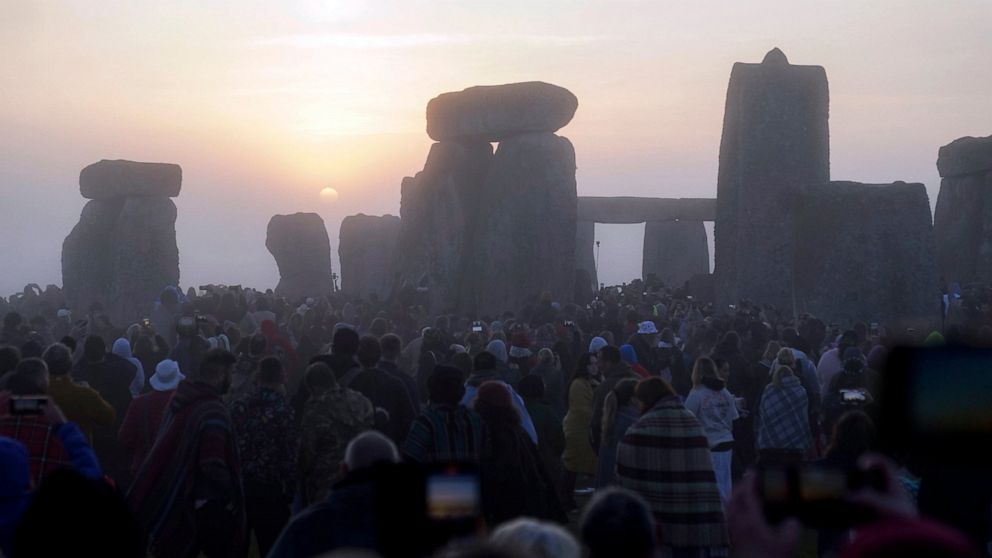 21 Haziran 2022 Salı, İngiltere, Wiltshire'daki Stonehenge'deki Yaz Gündönümü şenliklerine katılmak için güneş doğarken toplanırken güneş taşların üzerine yükselmeye başlar. COVID-19 salgını nedeniyle iki yıl kapalı kaldıktan sonra Stonehenge yeniden açıldı