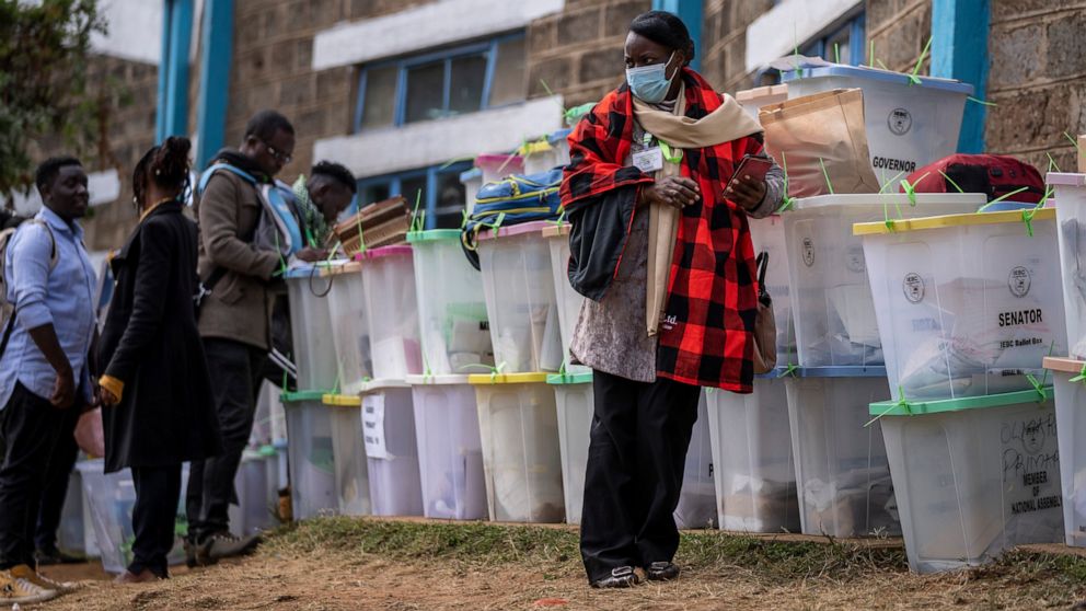 An electoral worker stands with ballot boxes lined up and ready to be stored at a collection and tallying center in Nairobi, Kenya Wednesday, Aug. 10, 2022. Kenyans are waiting for the results of a close but calm presidential election in which the tu