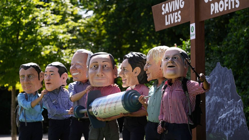 Activists from Oxfam wear giant heads depicting G7 leaders as they pose with a giant syringe during a demonstration in Munich, Germany, Saturday, June 25, 2022. The G7 Summit will take place at Castle Elmau near Garmisch-Partenkirchen from June 26 th