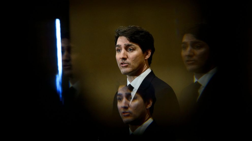 FILE - In this March 8, 2019, file photo, Prime Minister Justin Trudeau is seen through a beveled pane of glass in a door as he takes part in a news conference in Iqaluit, Nunavut, Canada. Nothing illegal is being alleged, but the no money, no sex sc