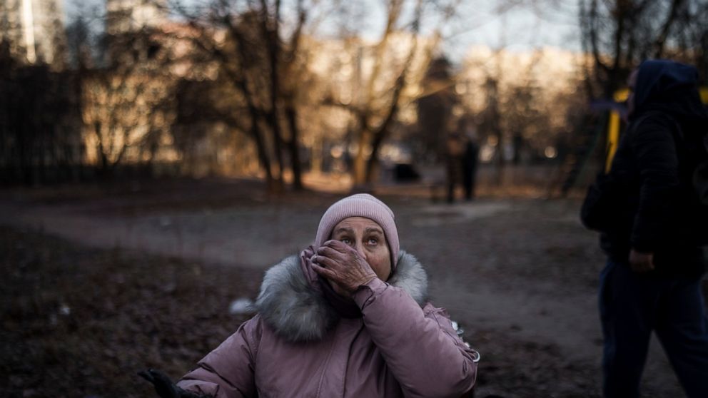 A woman reacts after being rescued by firefighters from her apartment in a burning building that was hit by artillery shells in Kyiv, Ukraine, Tuesday, March 15, 2022. (AP Photo/Felipe Dana)