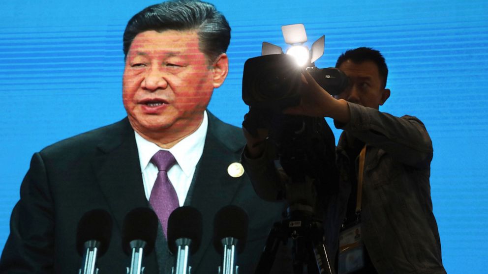 A cameraman films near a screen live broadcasting Chinese President Xi Jinping opening the Second Belt and Road Forum in Beijing Friday, April 26, 2019. The event celebrating the push for China-backed road, port and rail-building projects across the 