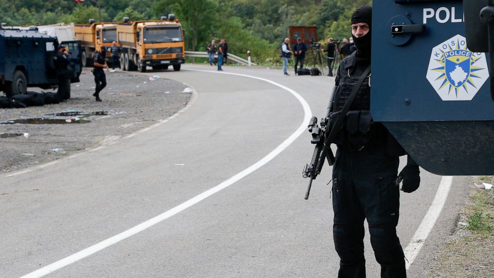 Kosovo police officers patrol a road near the northern Kosovo border crossing of Jarinje, Tuesday, Sept. 21, 2021. Tensions soared Monday when Kosovo special police with armored vehicles were sent to the border to impose a rule on temporarily replaci
