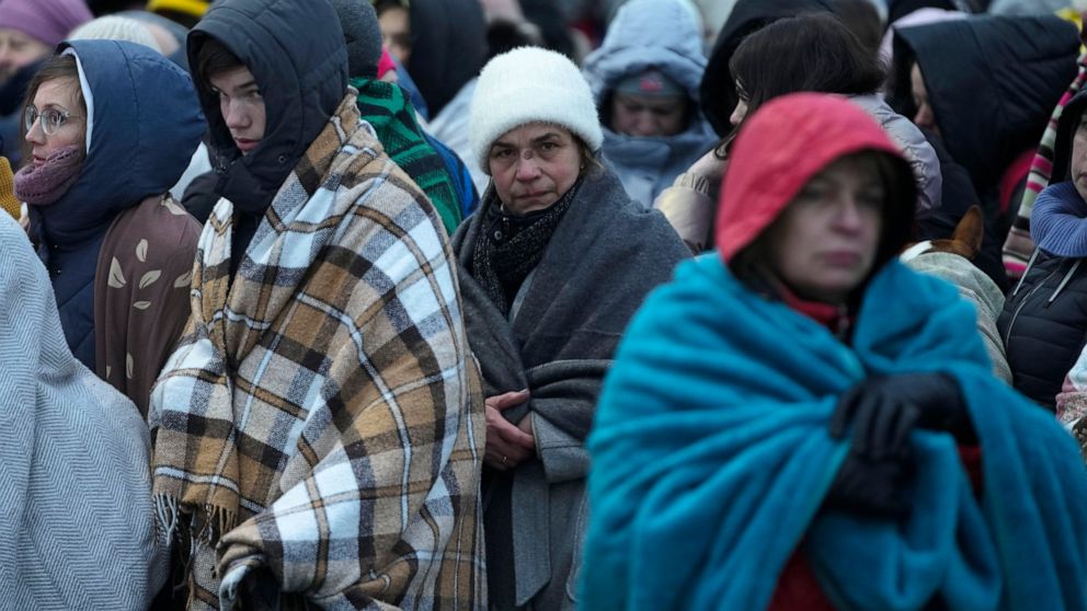 FILE - Refugees, mostly women and children, wait in a crowd for transportation after fleeing from the Ukraine and arriving at the border crossing in Medyka, Poland, on March 7, 2022. The U.N. refugee agency says more than 4 million refugees have now 