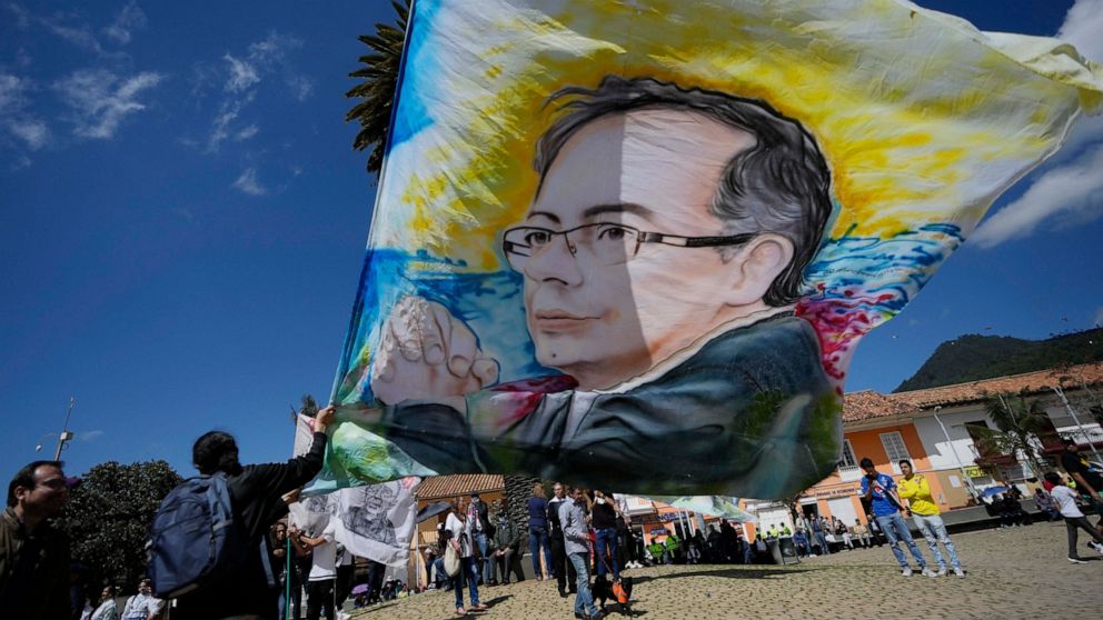 A supporter of Historical Pact coalition presidential candidate Gustavo Petro, holds a flag with the image of Petro before a closing campaign rally in Zipaquira, Colombia, Sunday, May 22, 2022. Elections are set for May 29. (AP Photo/Fernando Vergara)