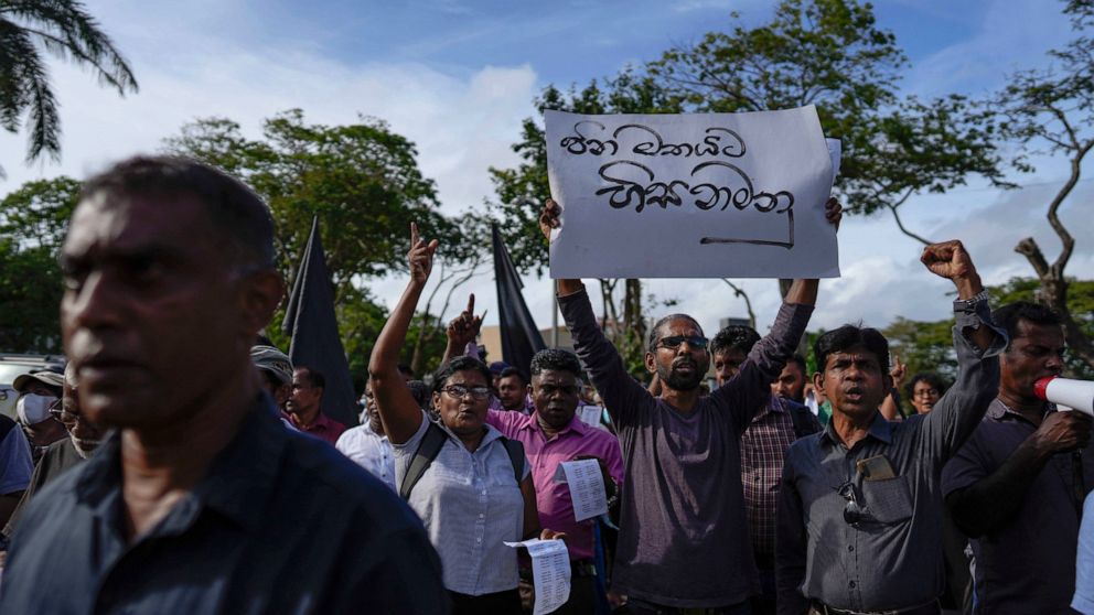 Trade union and civil society activists led by leftists' People Liberation Front shout slogans denouncing president Ranil Wickremesinghe in Colombo, Sri Lanka, Tuesday, Aug. 9, 2022. Placard in Sinhalese reads " Obey the people's mandate". Hundreds o