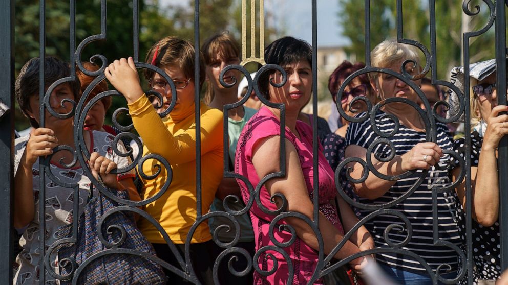 Local residents wait their turn to receive humanitarian aid at Saint-Strytensky Temple of the Orthodox Church of Ukraine, in Kostiantynivka, Donetsk region, eastern Ukraine, Friday, Aug. 19, 2022. (AP Photo/David Goldman)