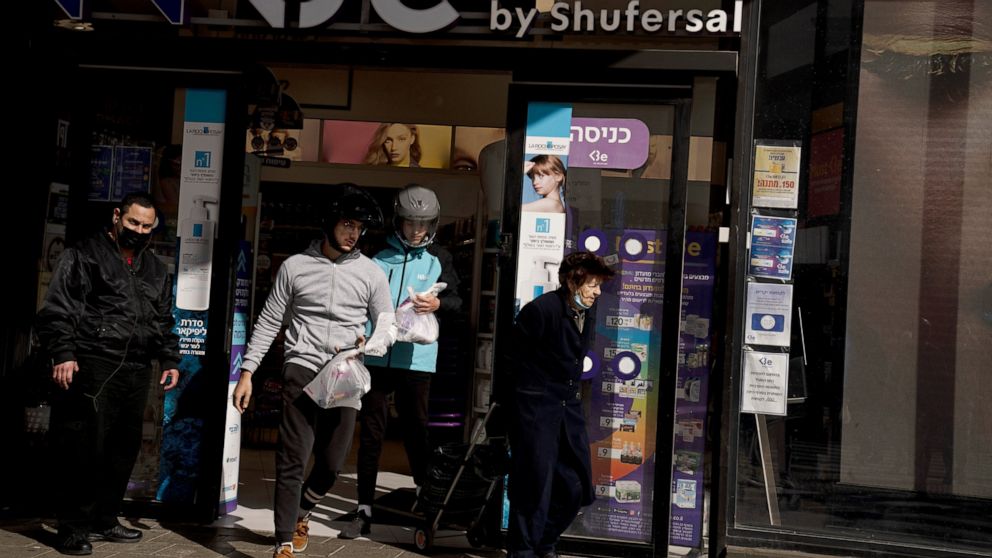 Delivery drivers from the Wolt app leave a pharmacy with rapid antigen tests for the coronavirus for delivery to customers in Tel Aviv, Israel, Monday, Jan. 10, 2022. Wolt, the Finnish company that's Israel's most visible delivery company says rapid 