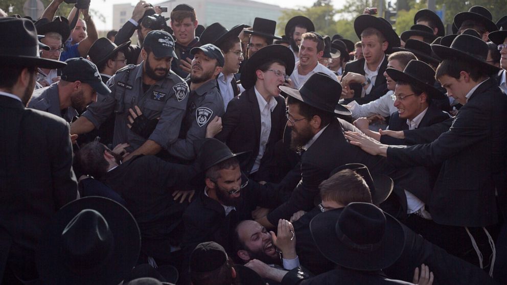 File - In this Oct. 19, 2017 file photo, Israeli police scuffle with ultra-Orthodox Jews as they block a main road during a protest against Israeli army conscription, in Jerusalem. The trigger for Israel's unprecedented repeat election in September 2