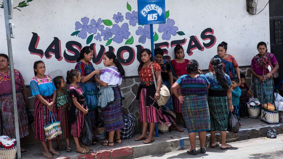 Women wait at a bus stop in the central park, of San Martin Jilotepeque, Guatemala, Sunday, August 4, 2019. San Martin Jilotepeque, like other towns in Guatemala, depends to a large extent on remittances, the money sent home by migrants living in the