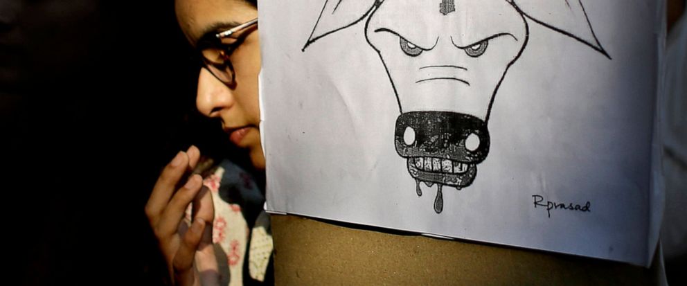 FILE - In this Oct. 2, 2015 file photo, a student activist holds a placard during a protest denouncing the killing of a 52-year-old Muslim farmer Mohammad Akhlaq by villagers upon hearing rumors that the family was eating beef, a taboo for many among
