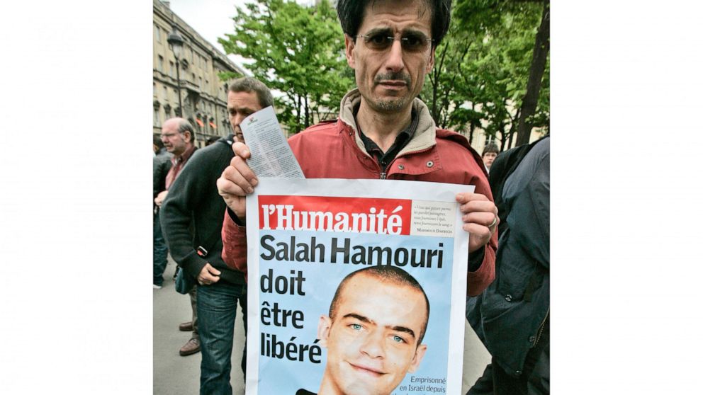 FILE - A member of a pro-Palestinian group holds a poster showing French-Palestinian Salah Hammouri, then detained in Israel after a sentencing by a military court, near the Foreign ministry in Paris to protest the visit of Israeli Foreign minister A