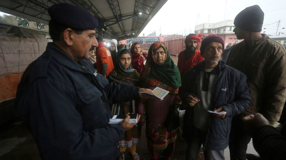 A Pakistani police officer checks documents of passengers travel to India via Samjhota Express at Lahore railway station in Pakistan, Thursday, Feb. 21, 2019. Indian authorities suspended a bus service this week without explanation. The development c