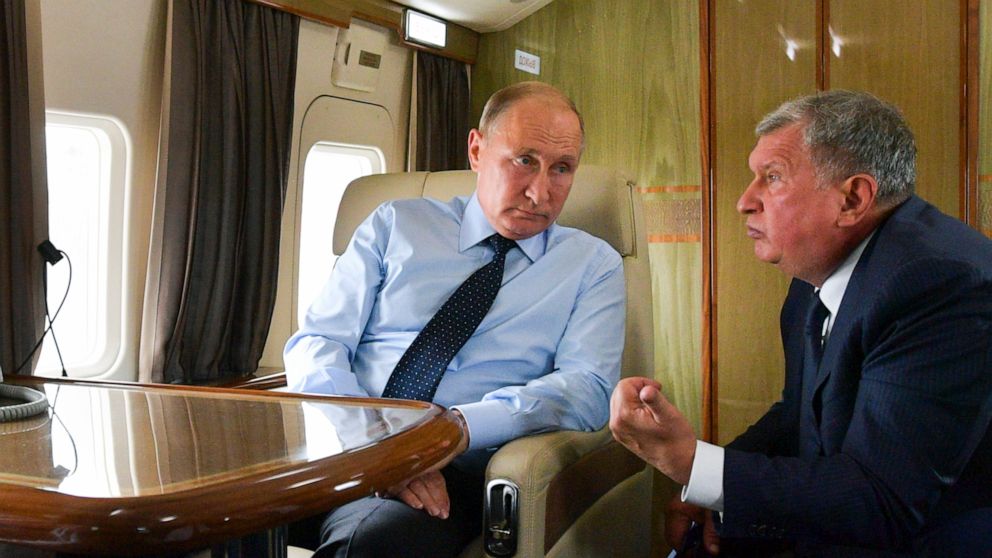 FILE - In this Aug. 27, 2018 file photo, Russian President Vladimir Putin, left, listens to Russian Rosneft CEO Igor Sechin during his flight to visit Chernigovets coal mine, in Beryozovsky, Kemerovo region, Russia. On Tuesday, Feb. 18, 2020, the Tre