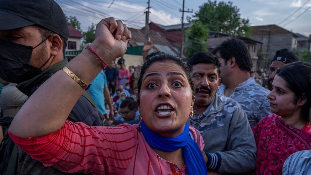 FILE- A woman from the minority Kashmiri Hindus, known as "pandits," shouts slogans as she along with others block the road during a protest against the killing of Rahul Bhat, a fellow Pandit, on the outskirts of Srinagar, Indian controlled Kashmir, 