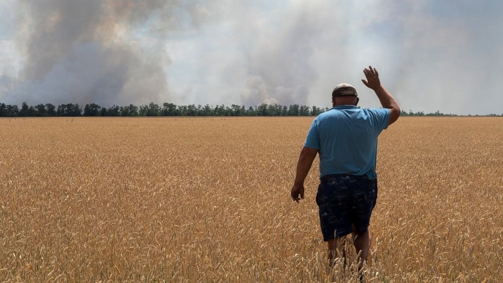 A farmer reacts as he looks at his burning field caused by the fighting at the front line in the Dnipropetrovsk region, Ukraine, Monday, July 4, 2022. An estimated 22 million tons of grain are blocked in Ukraine, and pressure is growing as the new ha